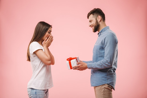 Porträt eines glücklichen jungen Mannes, der seine Freundin gibt