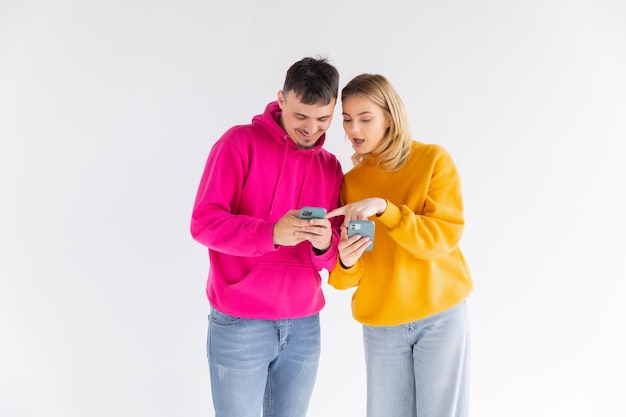 Porträt eines glücklichen jungen Paares, das Daumen hoch zeigt, während es zusammen ein Selfie macht