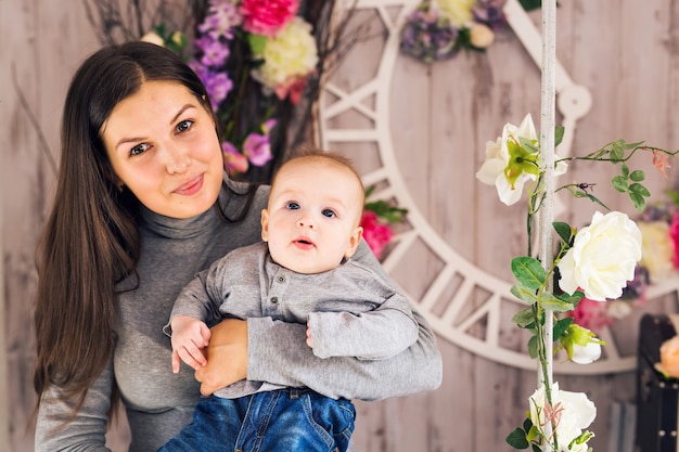 Porträt eines glücklichen Kindes mit blauen Augen mit seiner Mutter drinnen