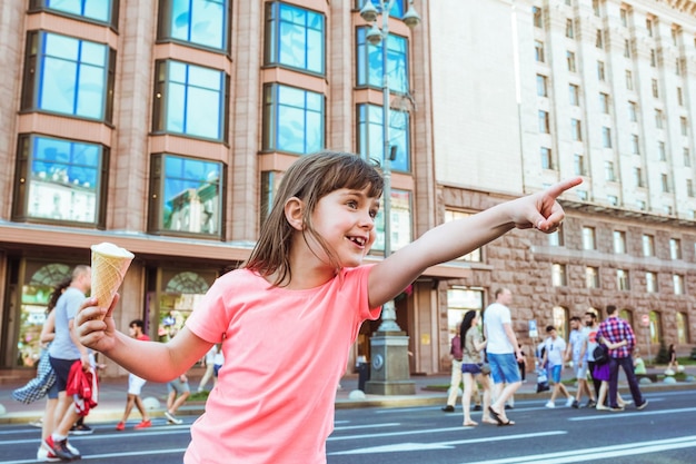 Porträt eines glücklichen Kindes mit Eis in den Händen auf einer Stadtstraße