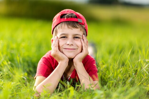 Porträt eines glücklichen kleinen Jungen auf dem Gras