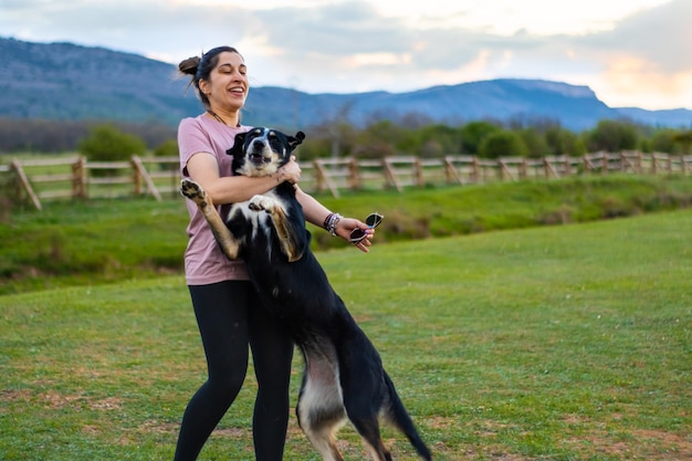Porträt eines glücklichen Mädchens, das mit seinem Hund auf dem Feld spielt