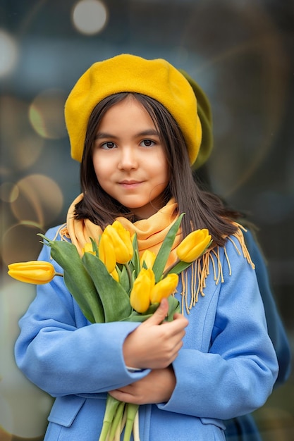 Porträt eines glücklichen Mädchens mit einem Strauß gelber Tulpen auf einem Frühlingsspaziergang Blumen zum Internationalen Frauentag