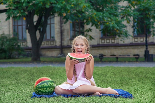 Porträt eines glücklichen Mädchens mit Wassermelone, die tagsüber den Sommer im Freien genießt