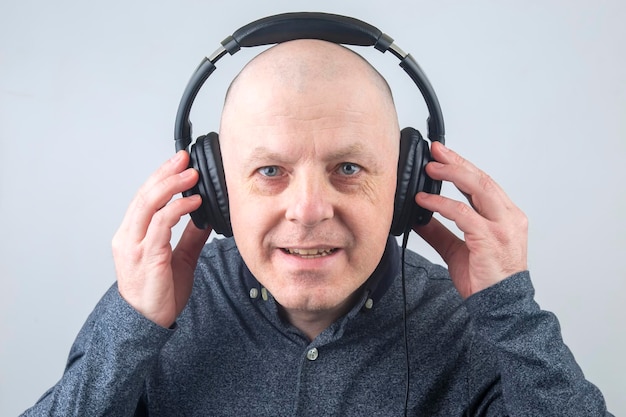 Porträt eines glücklichen Mannes mit Kopfhörern, der Musik hört