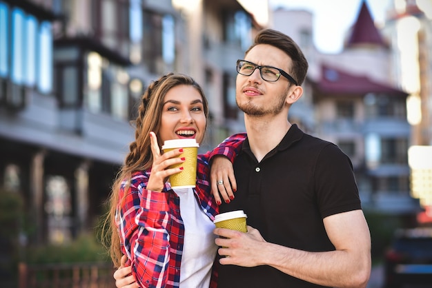Porträt eines glücklichen Paares geht mit Kaffee auf die Straße