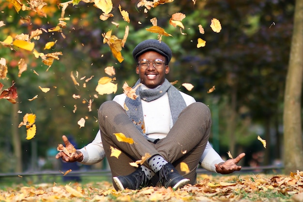 Porträt eines glücklichen, positiven schwarzen jungen afrikanischen Afroamerikaners sitzt und hat Spaß in