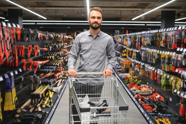 Porträt eines glücklichen reifen Mannes, der in einem Eisenwarenladen steht