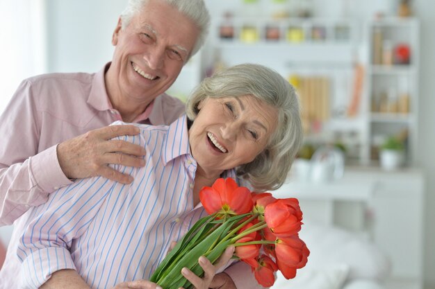 Porträt eines glücklichen reifen Paares mit Mohnblumen