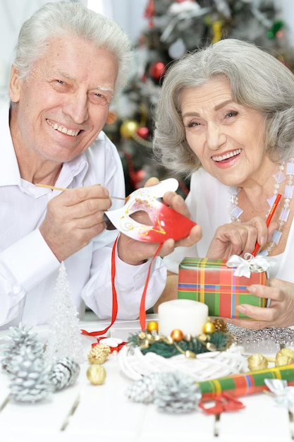 Porträt eines glücklichen Seniorenpaares in Weihnachtsmützen, das sich auf Weihnachten oder Neujahr vorbereitet