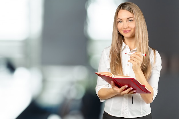 Porträt eines glücklichen Studentenmädchens oder -frau mit Büchern in der Bibliothek