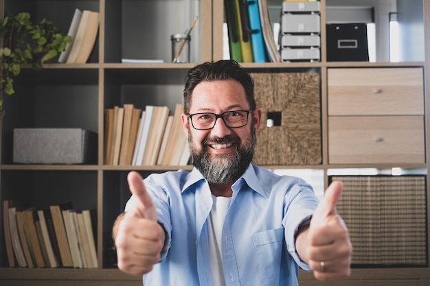 Porträt eines glücklichen und fröhlichen Mannes, der mit der Hand des Fingers nach oben lächelt und in die Kamera schaut. Männlicher Geschäftsmann, der Spaß hat, nachdem er gute Nachrichten von der Arbeit erhalten hat