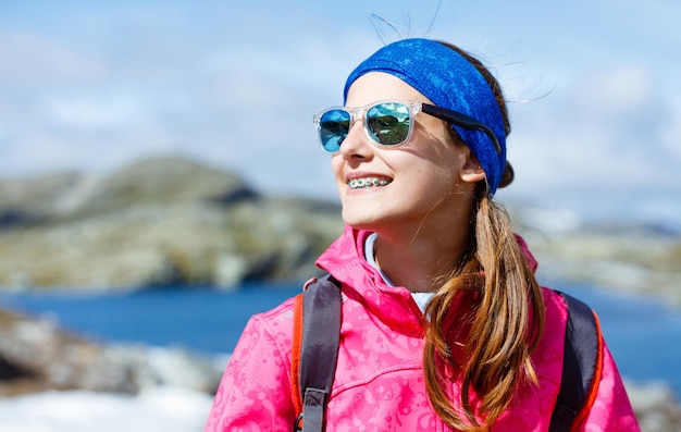 Porträt eines glücklichen Wandermädchens mit Trekkingstöcken in den Bergen. Norwegen