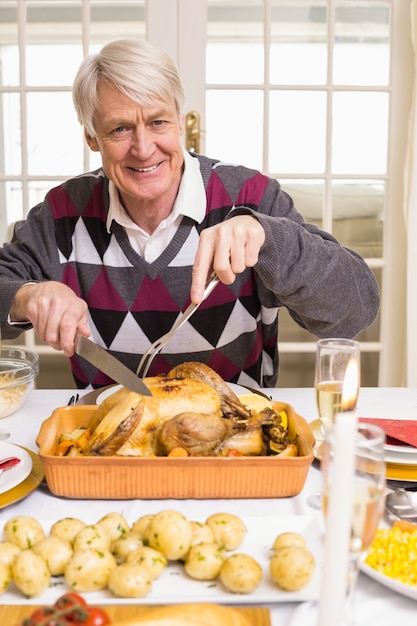 Porträt eines Großvaters, der Bratentruthahn am Weihnachten schnitzt