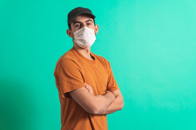 Porträt eines gutaussehenden jungen Mannes mit chirurgischer medizinischer Maske, der in die Kamera schaut