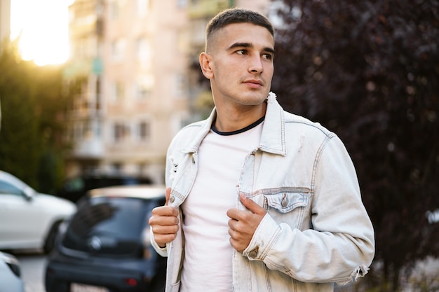 Porträt eines gutaussehenden jungen zufälligen Mannes, der auf die Straße geht