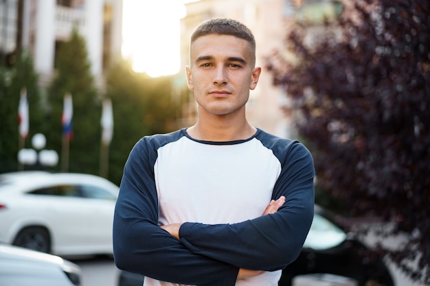 Porträt eines gutaussehenden jungen zufälligen Mannes, der auf die Straße geht