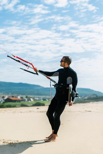 Porträt eines gutaussehenden Kitesurfers am Strand.