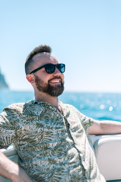 Porträt eines gutaussehenden Mannes, der auf einem Boot am Mittelmeer lächelt