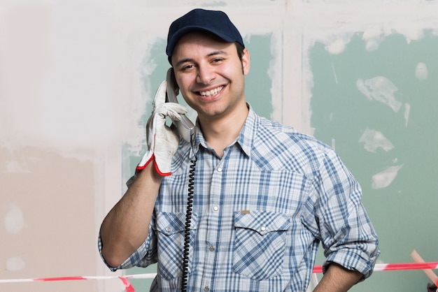 Porträt eines Handwerkers, der am Telefon spricht