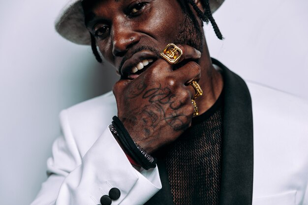 Porträt eines Hip-Hop-Musiker Filmisches Bild eines Mannes, der weiße Kleidung und Juwelen trägt