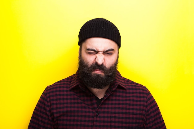 Porträt eines Hipster-Mannes mit langem Bart auf gelbem Hintergrund