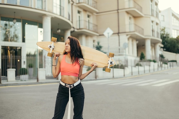 Porträt eines hispanischen Mädchens mit Skateboard auf einem Spaziergang Platz kopieren