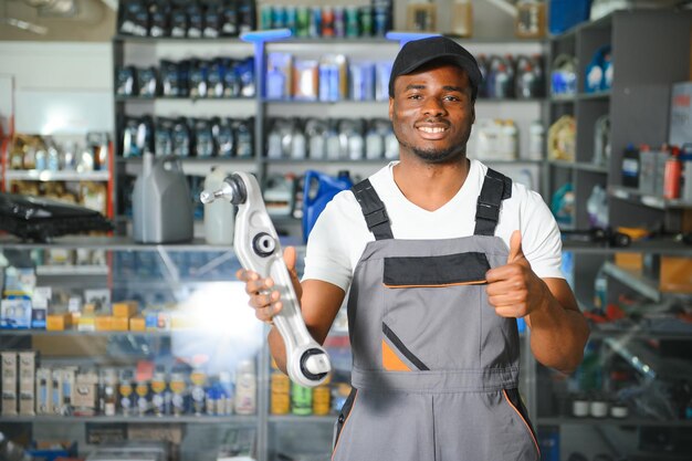 Foto porträt eines hübschen afrikanischen verkäufers in einem autoteilsalon das konzept der autoreparatur