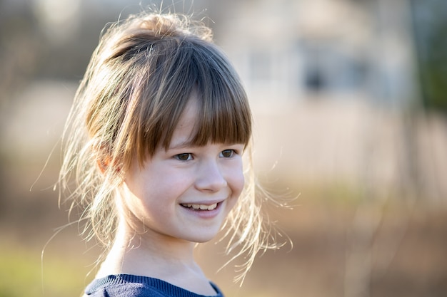 Porträt eines hübschen Kindermädchens im Freien an einem sonnigen warmen Herbsttag.