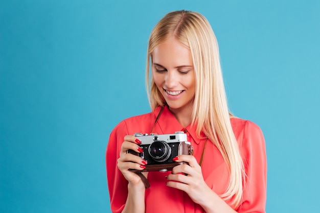 Porträt eines hübschen lässigen blonden Mädchens mit Retro-Front über blauer Wand