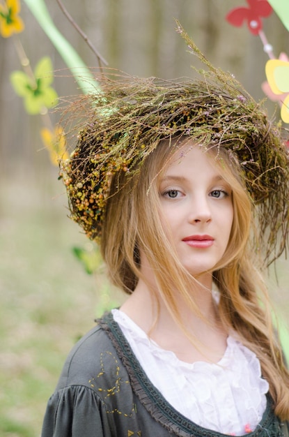 Porträt eines hübschen nachdenklichen Mädchens in einem volkstümlichen Blumenreif hautnah