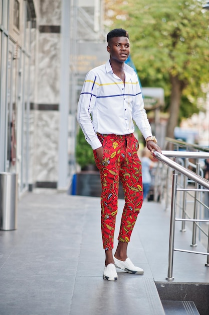 Porträt eines hübschen, stylischen afroamerikanischen Modellmanns in roter Hose und weißem Hemd