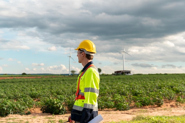 Porträt eines intelligenten Ingenieurs mit Schutzhelm auf dem Feld elektrischer Turbinen