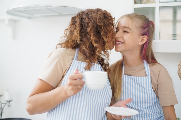 Porträt eines jugendlich Mädchens mit ihrer Mutter zu Hause in der Küche