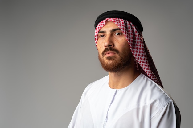 Porträt eines jungen arabischen Mannes auf grauem Hintergrund im Studio