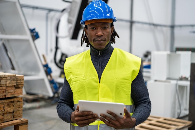 Porträt eines jungen Arbeiters mit einem Tablet in seinen Händen