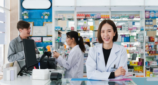 Porträt eines jungen asiatischen Apothekers mit Tablettenfläschchen in einer qualifizierten Apotheke