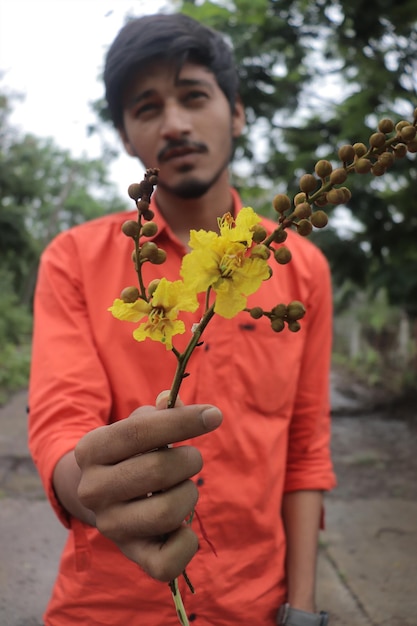 Porträt eines jungen asiatischen Mannes mit Blume