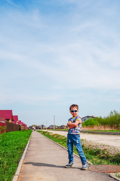 Porträt eines Jungen, der auf der Straße viel Himmel von oben steht