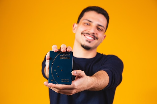 Porträt eines Jungen, der einen brasilianischen Pass in den Händen hält. Reise- und Migrationskonzept