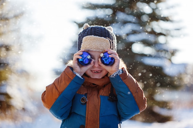 Porträt eines Jungen, der in die Winternatur geht. Spiel mit dem Schnee. Konzept glückliche Kindheit