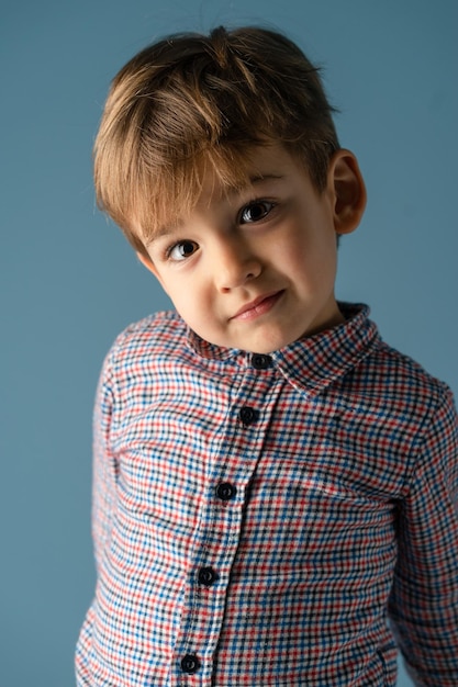 Porträt eines Jungen, der vor blauem Hintergrund steht