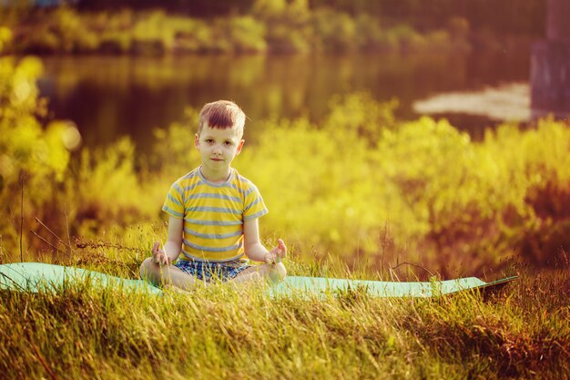 Porträt eines Jungen, der Yoga in der Natur tut