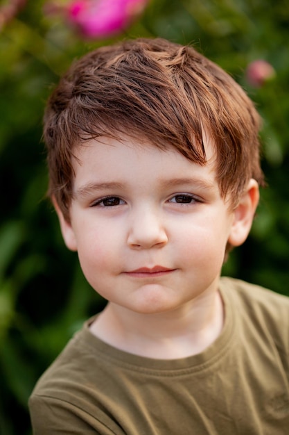 Porträt eines Jungen draußen bei natürlichem Licht, der Junge starrt direkt in die Kamera