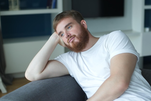 Foto porträt eines jungen europäers mit bart, nachdenklich, nachdenklich, entspannt, einsamer mann, der träumt und denkt, sich zu entspannen