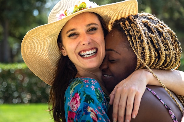 Porträt eines jungen gemischtrassigen lesbischen Paares, das sich im Freien umarmt, LGBT-Konzept Sommerzeit