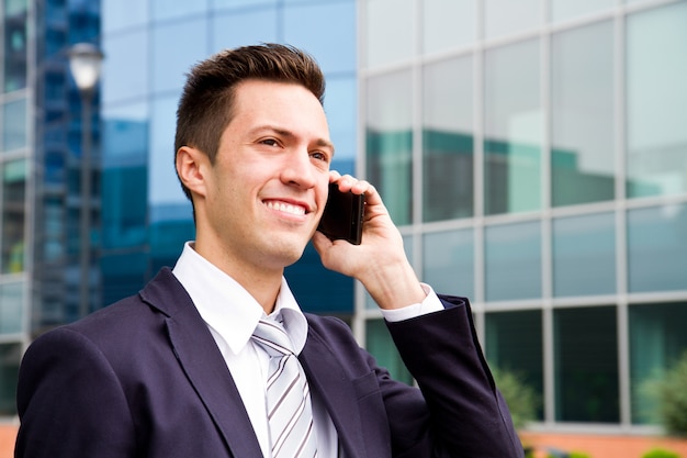 Porträt eines jungen Geschäftsmannes, der am Telefon spricht