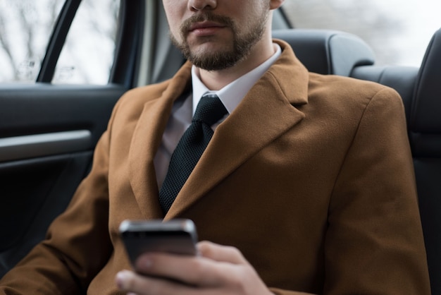 Porträt eines jungen Geschäftsmannes in einem Geschäftskleidungsstil auf dem Beifahrersitz
