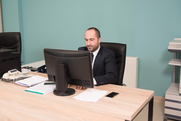 Porträt eines jungen Geschäftsmannes mit einem Computer im Büro