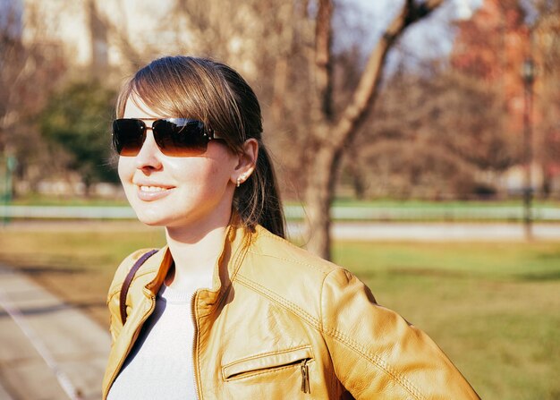 Porträt eines jungen glücklich lächelnden Mädchens mit Sonnenbrille auf der Straße von Moskau, Russland.